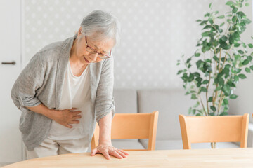 お腹が痛い高齢者女性
