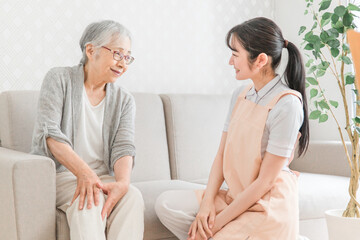 Obraz premium 訪問介護・膝をおさえる高齢者女性 