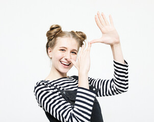 Pretty young woman making a funny gesture with her fingers over white background