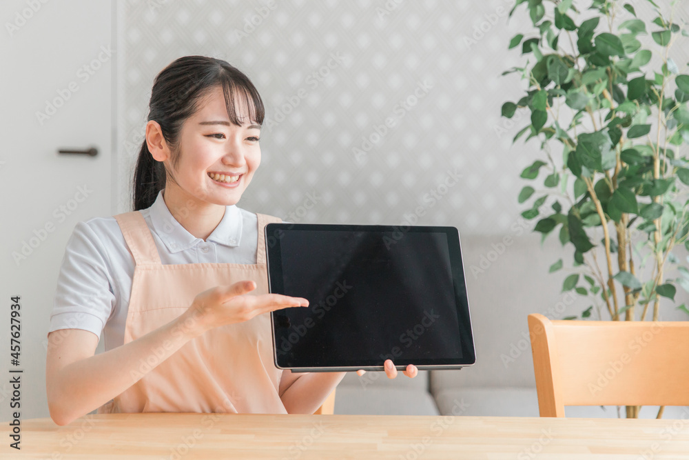 Wall mural タブレットPCで説明するエプロン姿の女性
