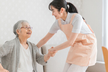 Obraz premium 訪問介護する女性と高齢者（笑顔） 