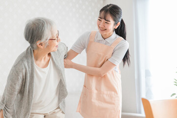 訪問介護する女性と高齢者（笑顔）
