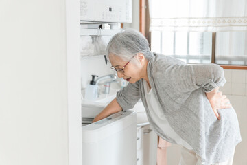 家事をして腰痛に苦しむ女性
