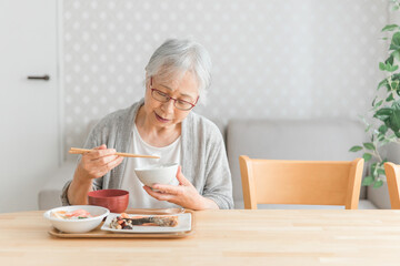 食事をする高齢者女性（食欲低下）
