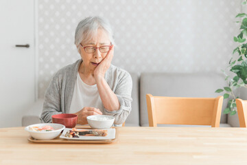 食事をする高齢者女性（痛い）
