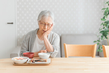 食事をする高齢者女性（痛い）
