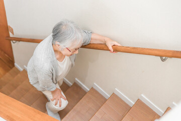 階段を登る高齢者女性
