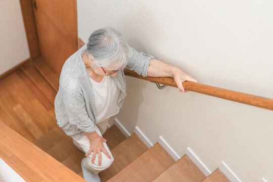 階段を登る高齢者女性

