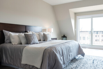 Bright window light in a modern bedroom staged for real estate sale