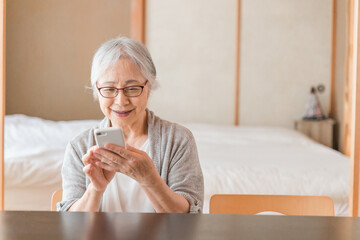 スマホを使う高齢者女性（アプリ）
