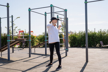 Happy woman working out on the sports ground in sunny summer day