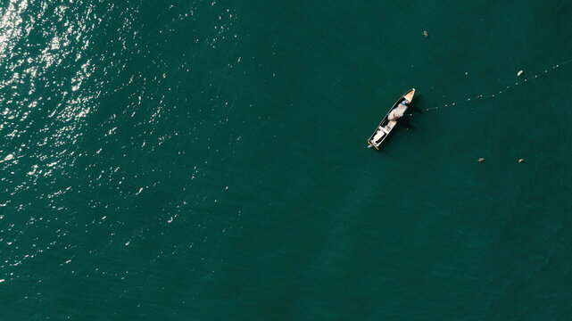 Pescadores en balsa sobre el mar azul con atarraya, Cartagena de Indias, Colombia