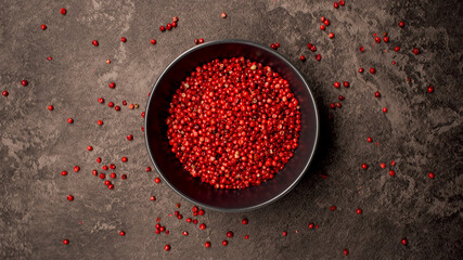 TOP VIEW: Dish with pink pepper seeds on a table - 457637914
