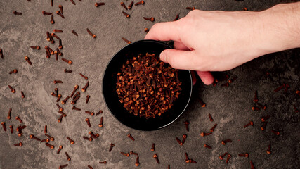 TOP VIEW: Human hand takes a dish with cloves from a table - 457637934