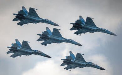 Three military fighter jets as part of a unit in the sky.