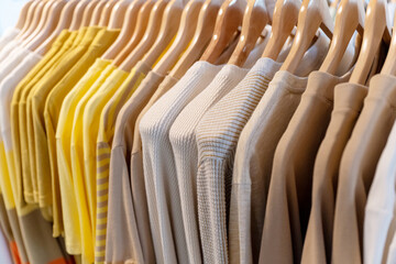 verschiedene Kleidungsstücke befinden auf einer Kleiderstange