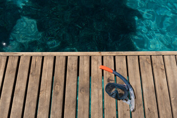 diving goggles on wooden floor in front of sea background