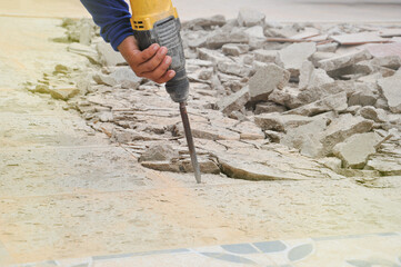 hand holding Jackhammer to break concrete on ground,selective focus