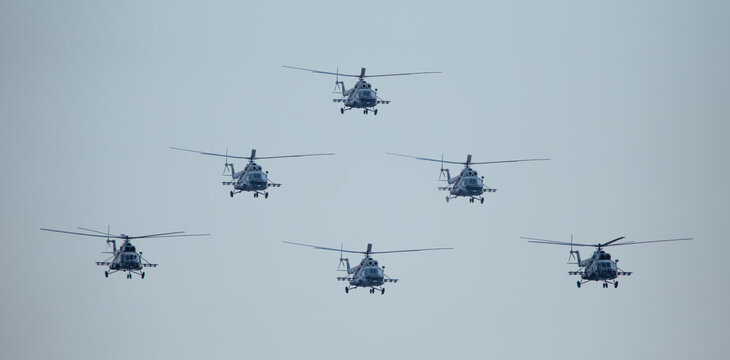 Group of military helicopters in the sky.