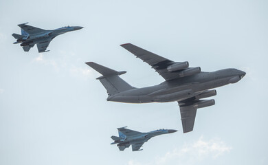 Military transport aircraft in the air covered by fighters.