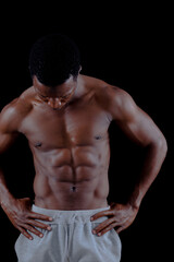 Fototapeta premium Muscled male model showing his muscles. on a black background