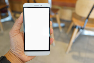 Adult hand holding a smartphone in a cafe restaurant with blank copy space screen for text message or information content