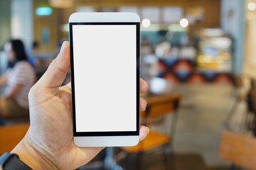 Adult hand holding a smartphone in a cafe restaurant with blank copy space screen for text message or information content