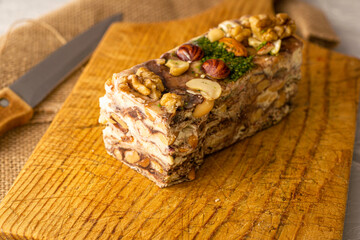 a piece of homemade tahini halva made of sesame on a wooden board close-up