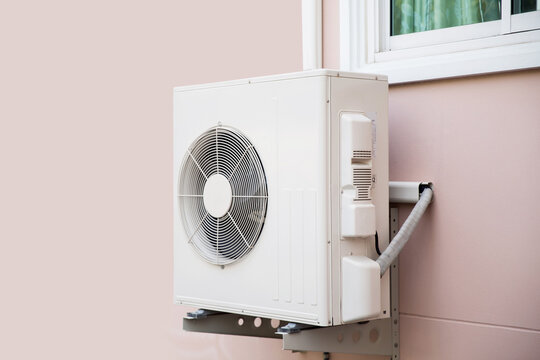 Air compressor, Close-up external split wall type of outdoor home air conditioner unit installed on outside building. Concepts of cool or heat or hot and air conditioning system maintenance.
