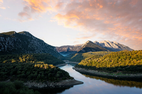 Stunning view of the Cedrino Lake (Lago del Cedrino) with the mountain range of Supramonte illuminated by a beautiful sunrise. Sardinia, Italy.