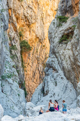 (Selective focus, focus) Defocused tourists admiring the spectacular Gorropu gorge . Gorropu is the deepest canyon in Europe located in the Supramonte area, Sardinia, Italy.