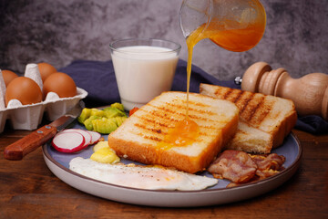 Breakfast bread with fried egg, bacon, pepper, avocado, tomato p