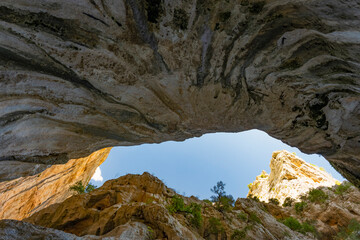 (Selective focus, focus) Stunning view from the bottom of the Gorropu gorge framing a blue sky. Gorropu is the deepest canyon in Europe located in the Supramonte area, Sardinia, Italy.