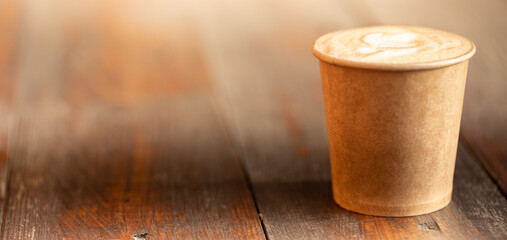 coffee in a paper cup on a wooden table