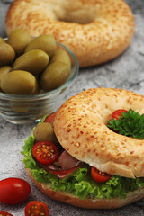 Sesame bagels with tomatoes, ham and olives
