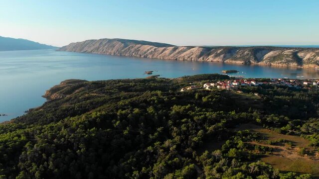 Drone footage of Rab Island, Lopar Area in Croatia. Early, calm morning after sunrise. Golden hour shoot with epic landscape, Adriatic blue sea and mountains.