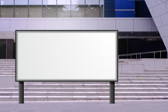 Large Blank Advertising Poster Billboard Banner Mockup In Front Of Building In Urban City; Digital Lightbox Display Screen For OOH Media. Speckled Textured Concrete Cement Staircase In Background