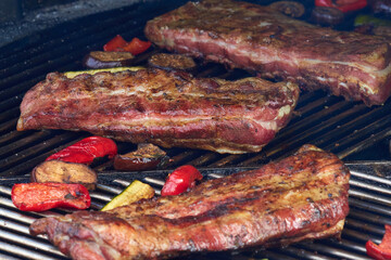 Large cuts of grilled meat with vegetables