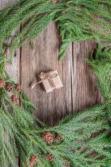 small gift box on a wooden background decorated branch of pine tree for new year