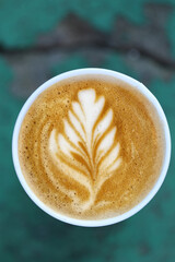 coffee in a paper cup on a wooden table