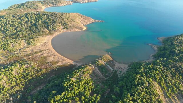 Drone footage of Rab Island, Lopar Area in Croatia. Early, calm morning after sunrise. Golden hour shoot with epic landscape, Adriatic blue sea.