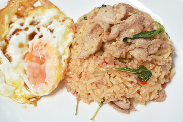spicy stir fried slice pork with chili and basil leaf mixed rice topping egg on plate 
