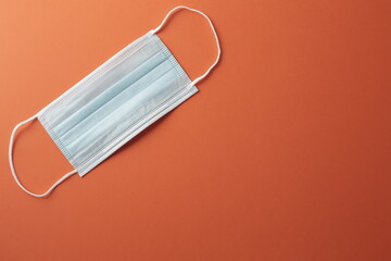 Respiratory medical masks on orange background. Coronavirus protection concept.