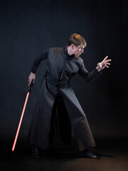 A villain with a red lightsaber, a young man in a long robe does fighting poses, - 457665961