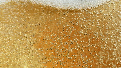 Close-up of champagne bubbles background with foam.