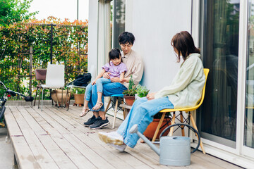 自宅の庭でリラックスをする女の子と家族