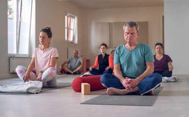 Group of different ages have meditation on Yoga class.