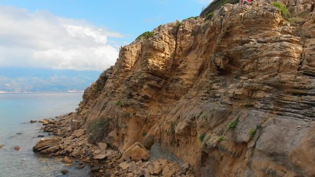 Drone footage of Rab Island, Lopar Area in Croatia. Orange rock cliffs and epic landscape, Adriatic blue sea and mountains.