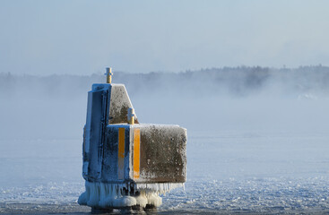 Ice covered mooring pollard or docking pillar by the Baltic sea in Helsinki, Finland.