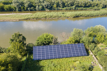 Aerial view of blue photovoltaic solar panels mounted on backyard ground for producing clean ecological electricity. Production of renewable energy concept.
